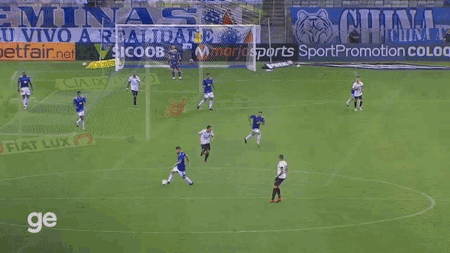 a group of soccer players are playing on a field with an ad for sicoob behind them