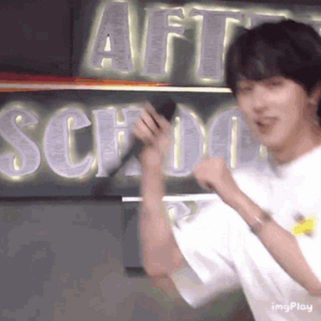 a man is standing in front of a sign that says art school .