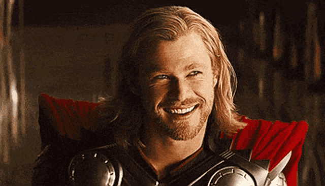 a man with long blonde hair and a beard is smiling for the camera