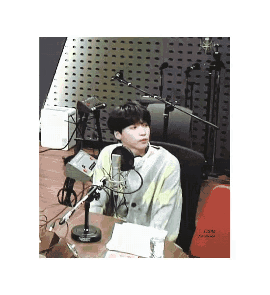 a young man is sitting in front of a microphone in a radio studio .