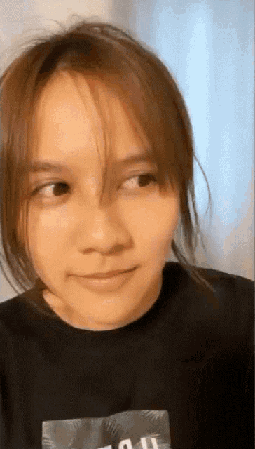 a close up of a woman wearing a black shirt with the word all on it