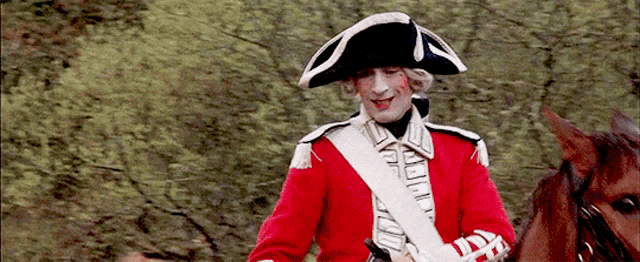 a man in a red and white uniform is riding a horse