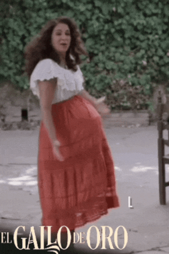 a woman in a red skirt is dancing in front of a sign that says " el gallo de oro "