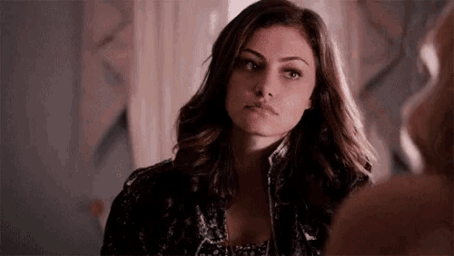 a woman is looking at herself in a mirror and making a funny face .
