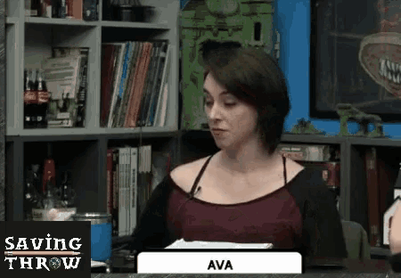 a woman is sitting at a table with a sign that says ava .