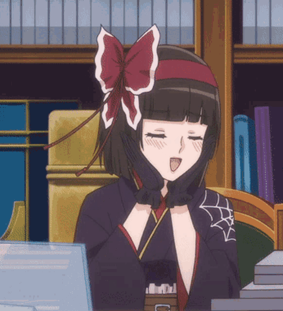 a girl with a red bow on her head is sitting at a desk