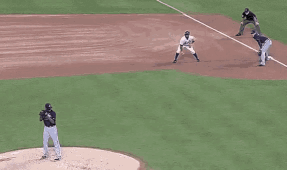 a baseball game is being played on a baseball field with a pitcher getting ready to throw the ball .