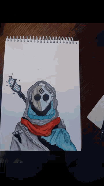 a drawing of a person with a hood and scarf on a notebook