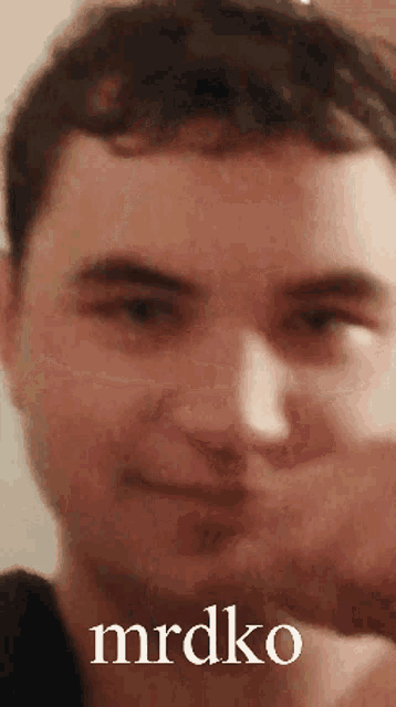 a close up of a man 's face with the word mrdko written below it