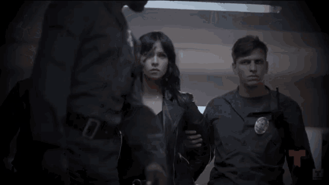 a woman in a leather jacket is being led by a man