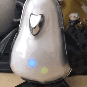 a close up of a penguin shaped speaker on a desk .