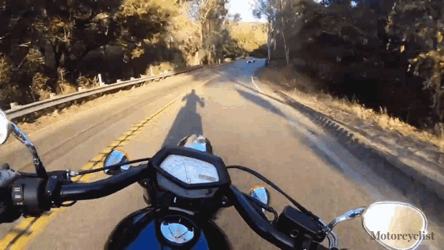 a person riding a motorcycle down a road with the word motorcyclist written on the bottom