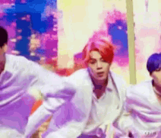a group of young men are dancing on a stage . one of the men has red hair .