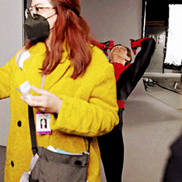 a woman wearing a yellow coat has a name tag that says a on it