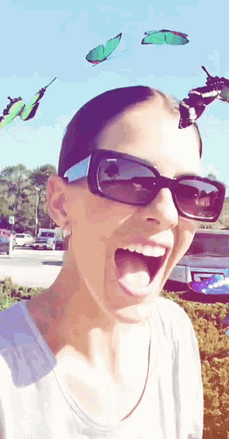 a woman wearing sunglasses is surrounded by butterflies
