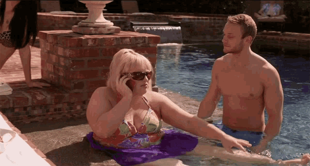 a woman in a bikini is talking on a cell phone in a pool