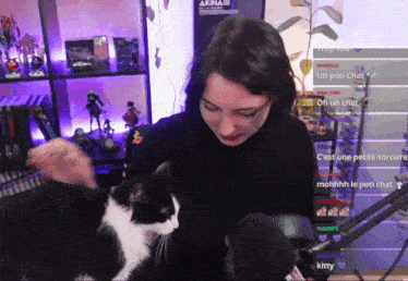 a woman petting a black and white cat in front of a sign that says akina on it