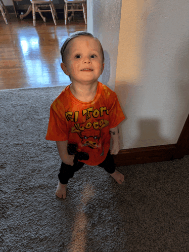 a little boy wearing an orange shirt that says el toro loco on it