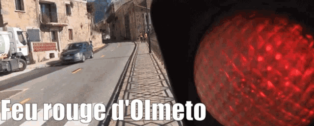 a sign that says feu rouge d' olmeto next to a traffic light