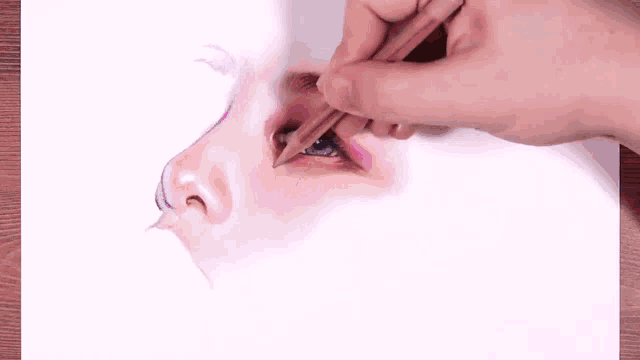a person is drawing a woman 's nose with a pencil