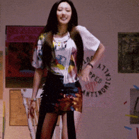a woman is standing in front of a wall that has a circle that says " attitude " on it