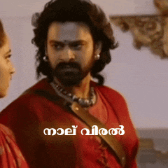 a man with a beard is standing next to a woman in a red shirt with a caption in malayalam