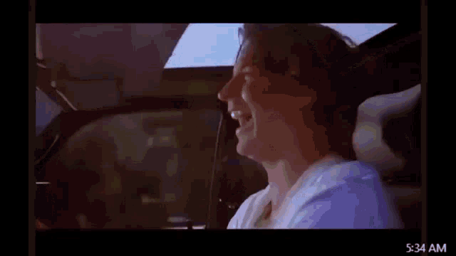 a man is driving a car with the time of 5:34 am