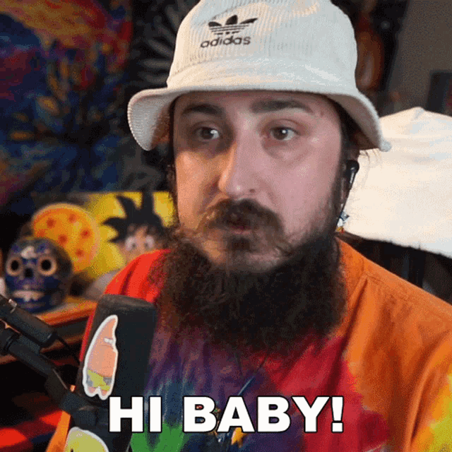 a man with a beard wears an adidas hat