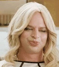 a close up of a person wearing a wig making a funny face .