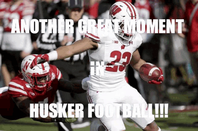 a football player with the number 23 on his jersey runs with the ball