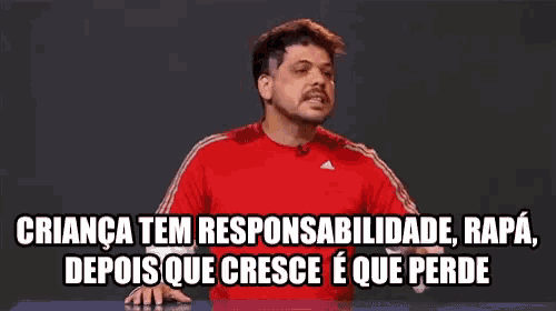 a man in a red shirt is talking in a foreign language