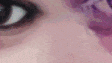 a close up of a woman 's eye with a purple background