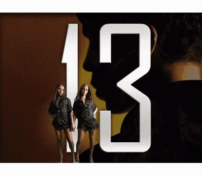a man and two women are standing in front of a large number 13