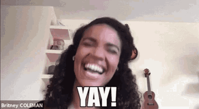 a woman is laughing and saying yay while looking at the camera .