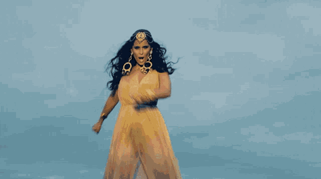 a woman in a yellow dress is dancing in the air