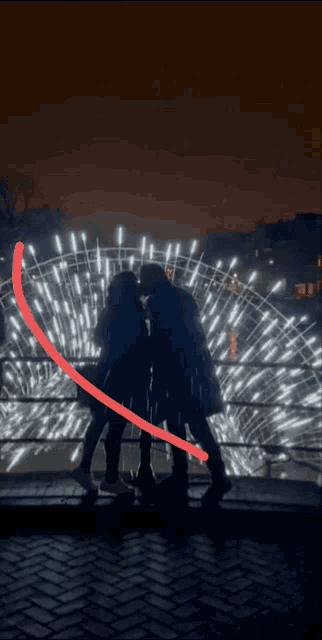 a man and woman kissing in front of a ferris wheel