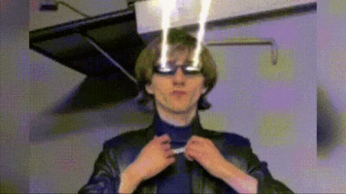 a man wearing glasses and a leather jacket is adjusting his collar .