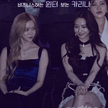 a woman in a blue dress sits next to a woman in a white dress