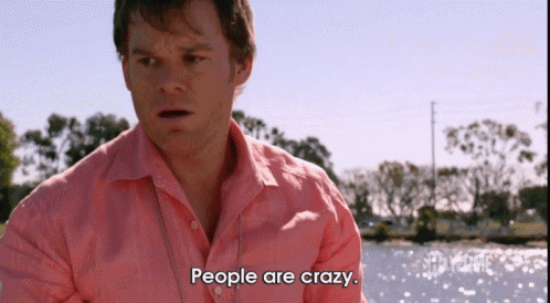 a man in a pink shirt says " people are crazy " in front of a body of water