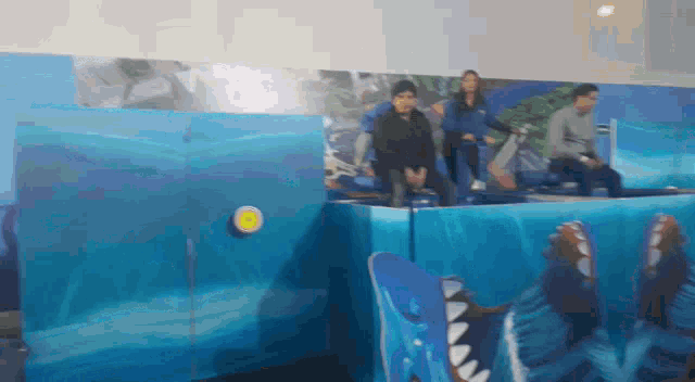 a group of people are sitting in front of a wall with a shark on it