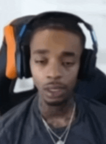 a man wearing headphones is sitting in a chair with his eyes closed .