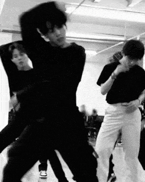 a group of young men are dancing together in a room .