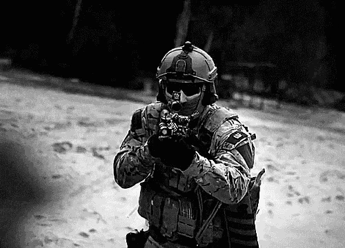 a black and white photo of a soldier wearing a helmet and holding a gun .