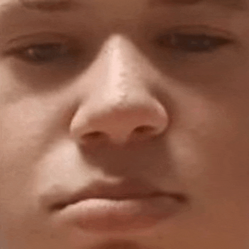 a close up of a person 's nose with a serious look on his face .