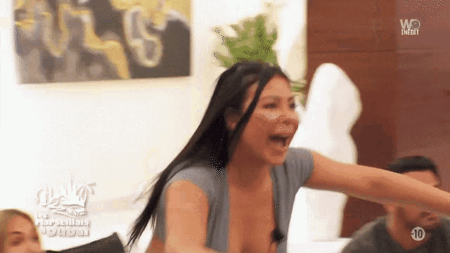a woman in a blue shirt is screaming in front of a group of people with the number 10 on the bottom right corner of the screen