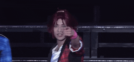 a man with red hair is dancing on a stage with another man
