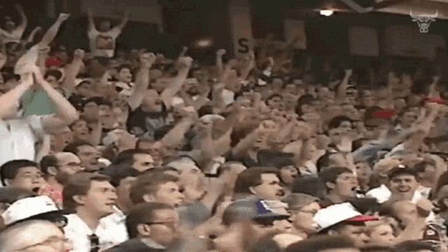 a crowd of people cheering in a stadium with a sign that says s on it