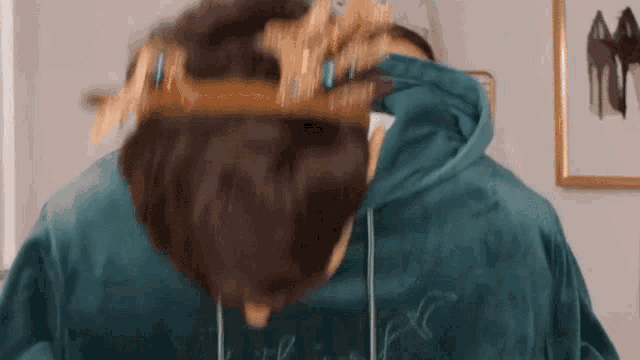 a person wearing a crown on their head and a blue hoodie