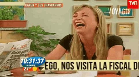 a woman laughs in front of a tv screen that says ego nos visita la fiscal di