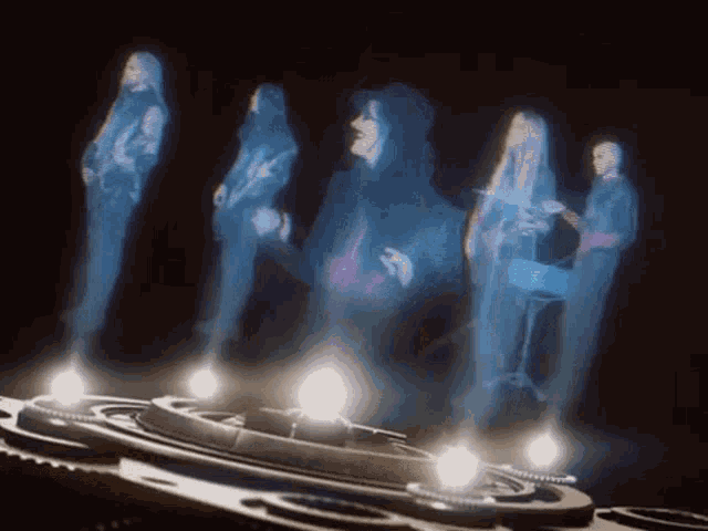 a group of ghosts are dancing and playing instruments in the dark